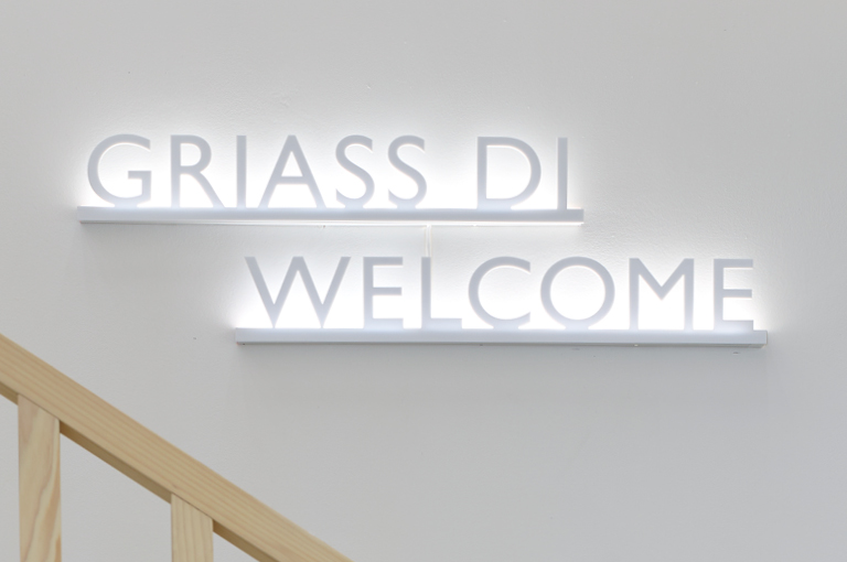 Foto mit Leuchtschrift „GRIASS DI WELCOME“