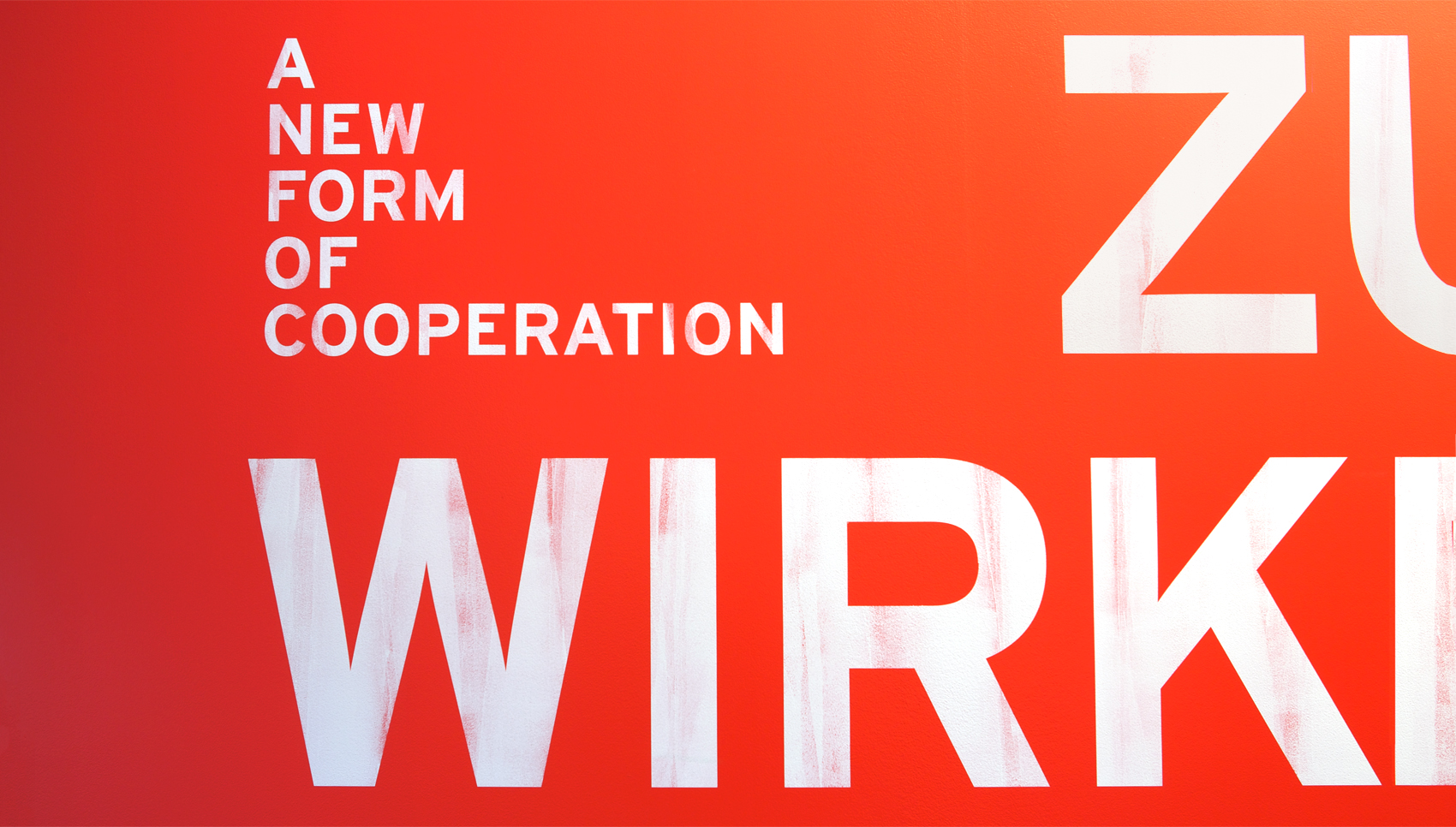 Grafik weiß auf Rot "A new form of cooperation"