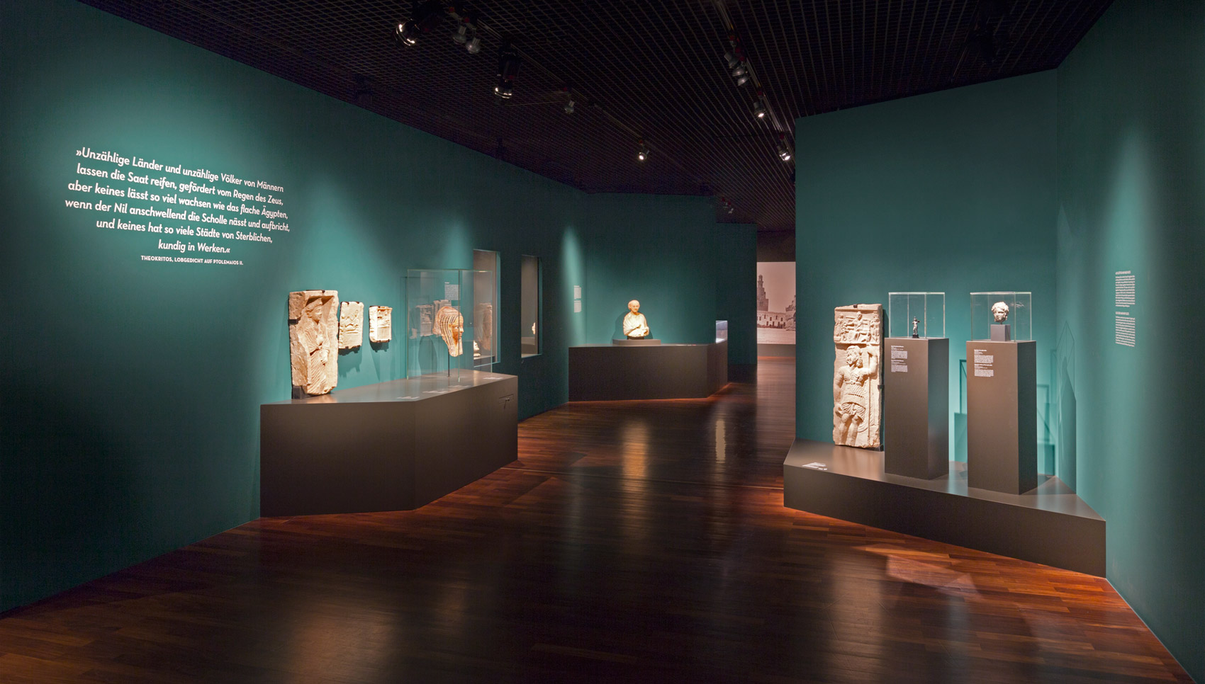 Blick in den Raum mit verschiedenen Podesten, Exponaten und Vitrinen