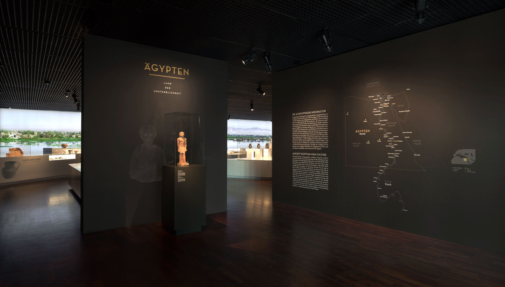 Schwarze Ausstellungswand mit weiß und goldenen Grafiken