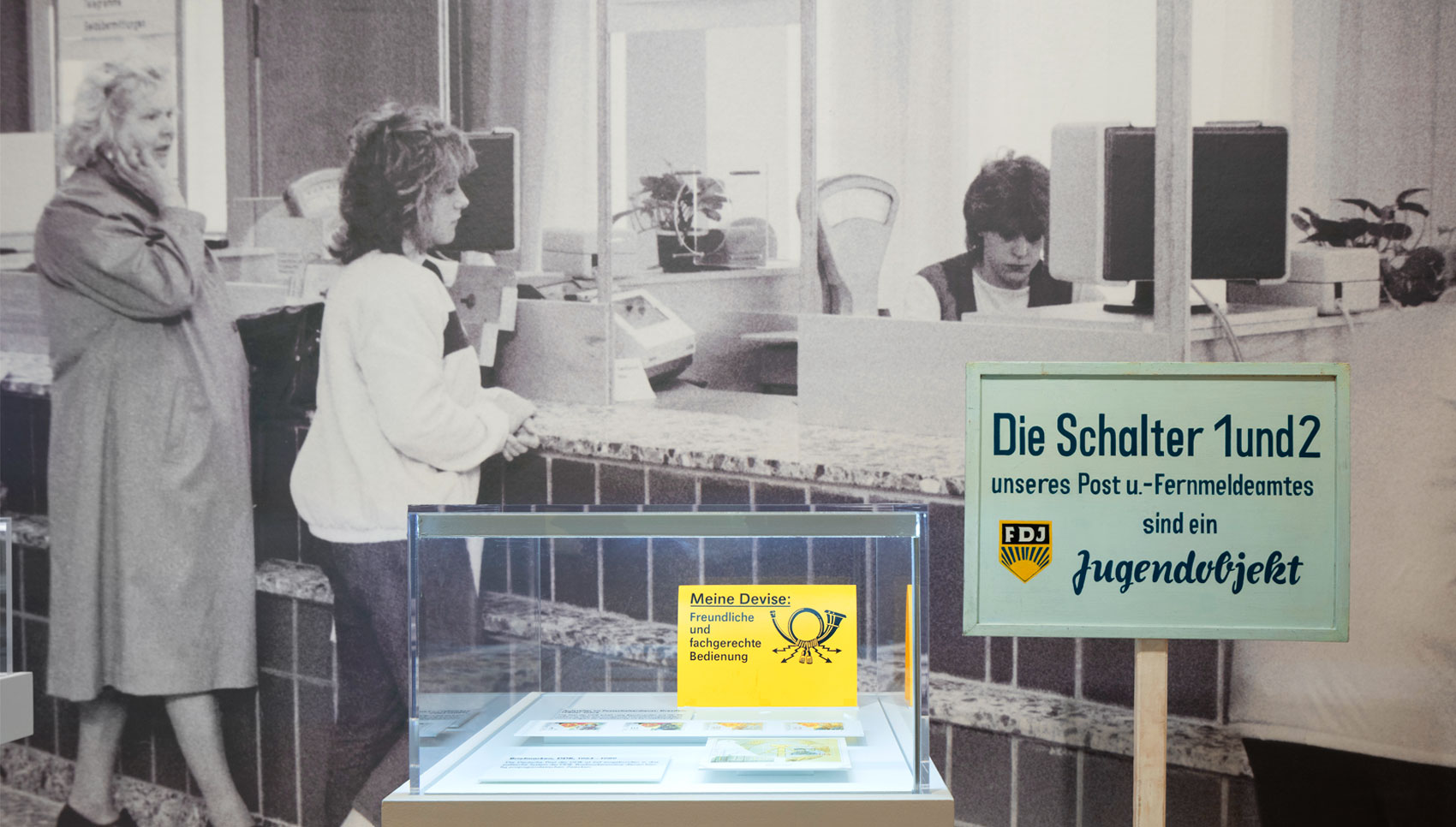 Aufsatzvitrine vor Fotowand