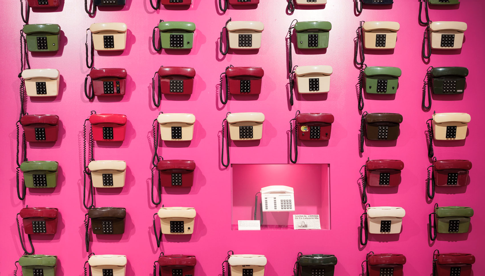 pink Wand mit alten Telefonen