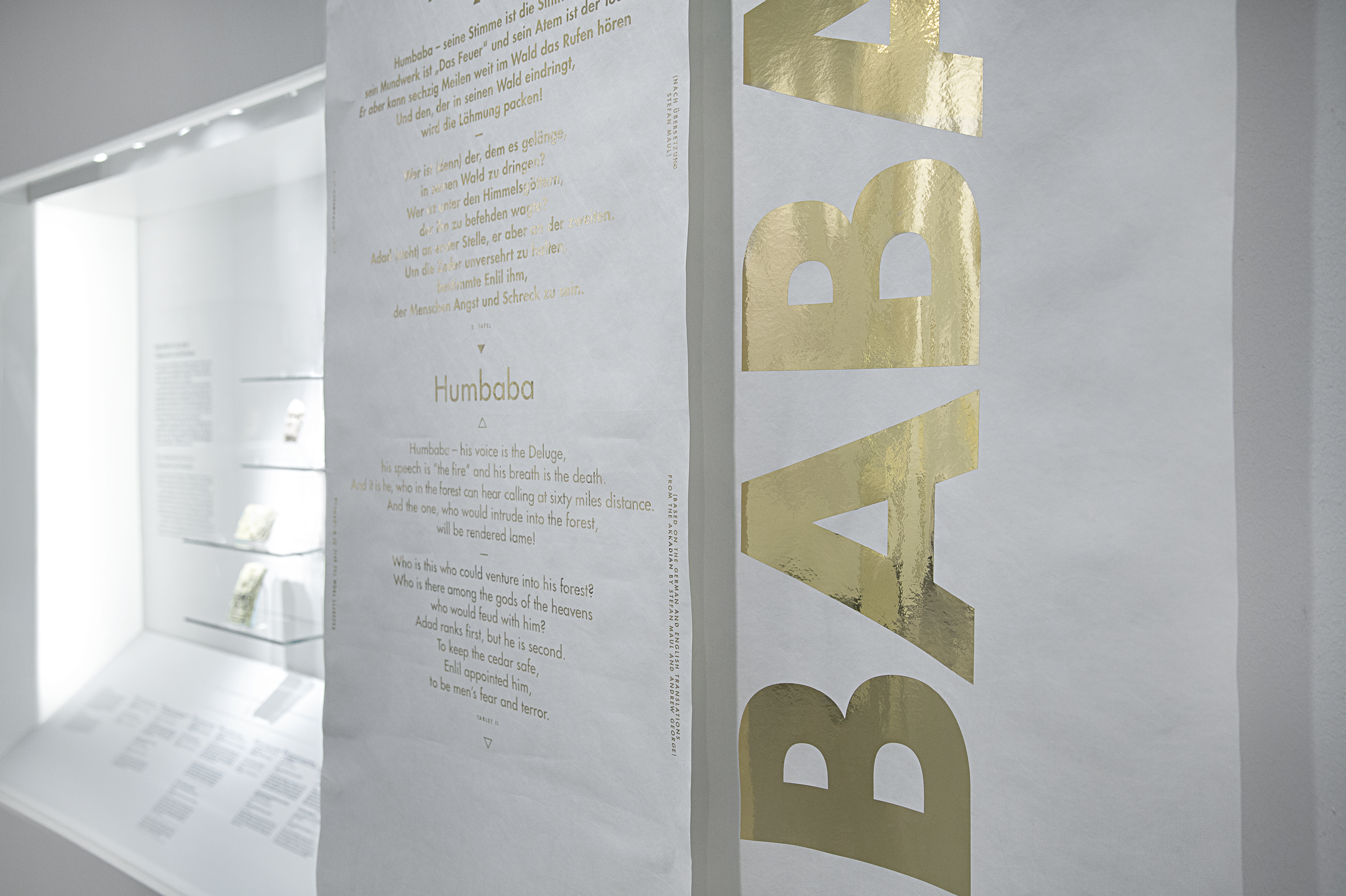 Nahaufname goldene Schrift auf Papier abgehängt vor weißer Ausstellungswand