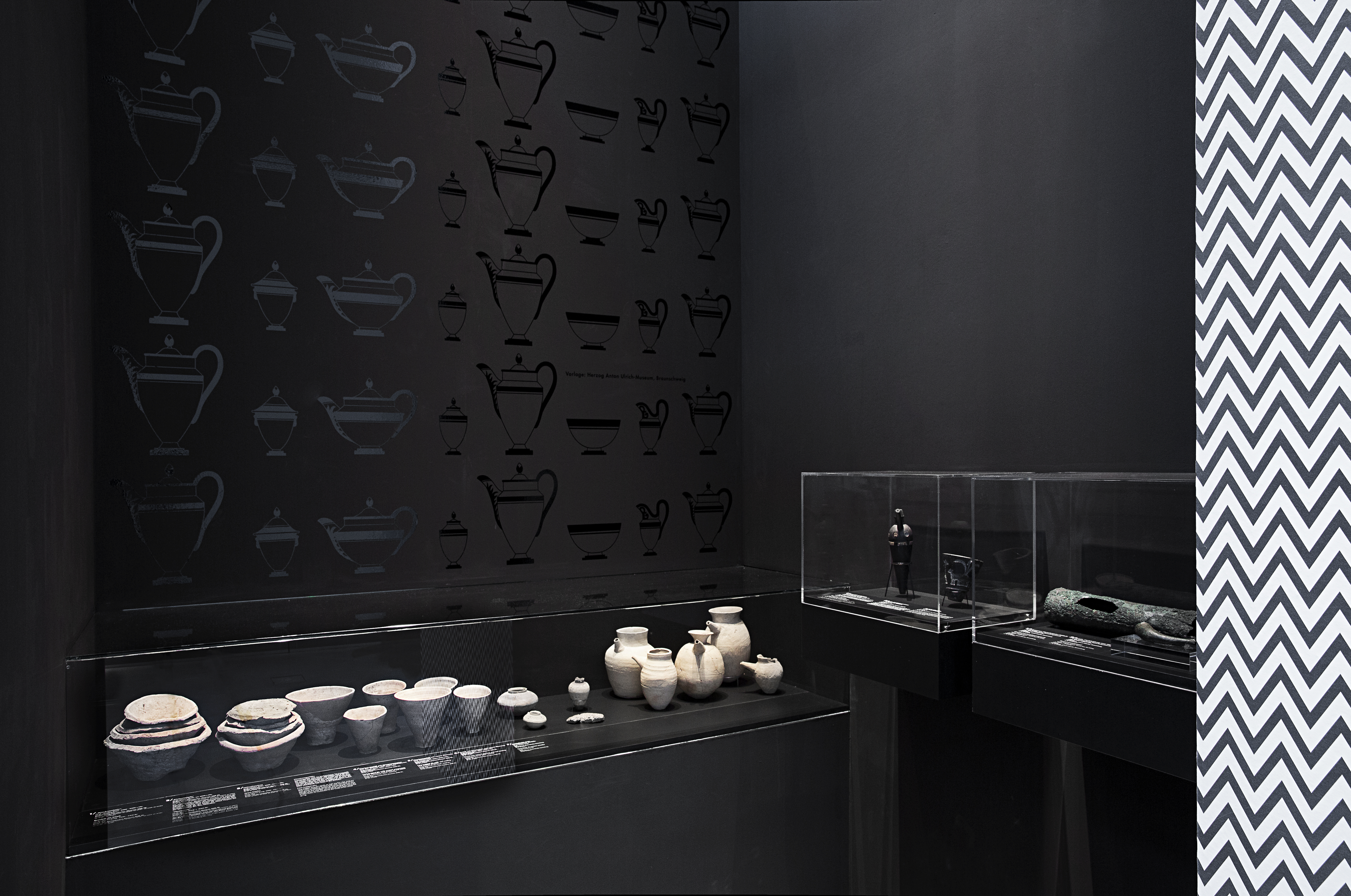 schwarzer Raum mit verschiedenen Aufsatzvitrinen