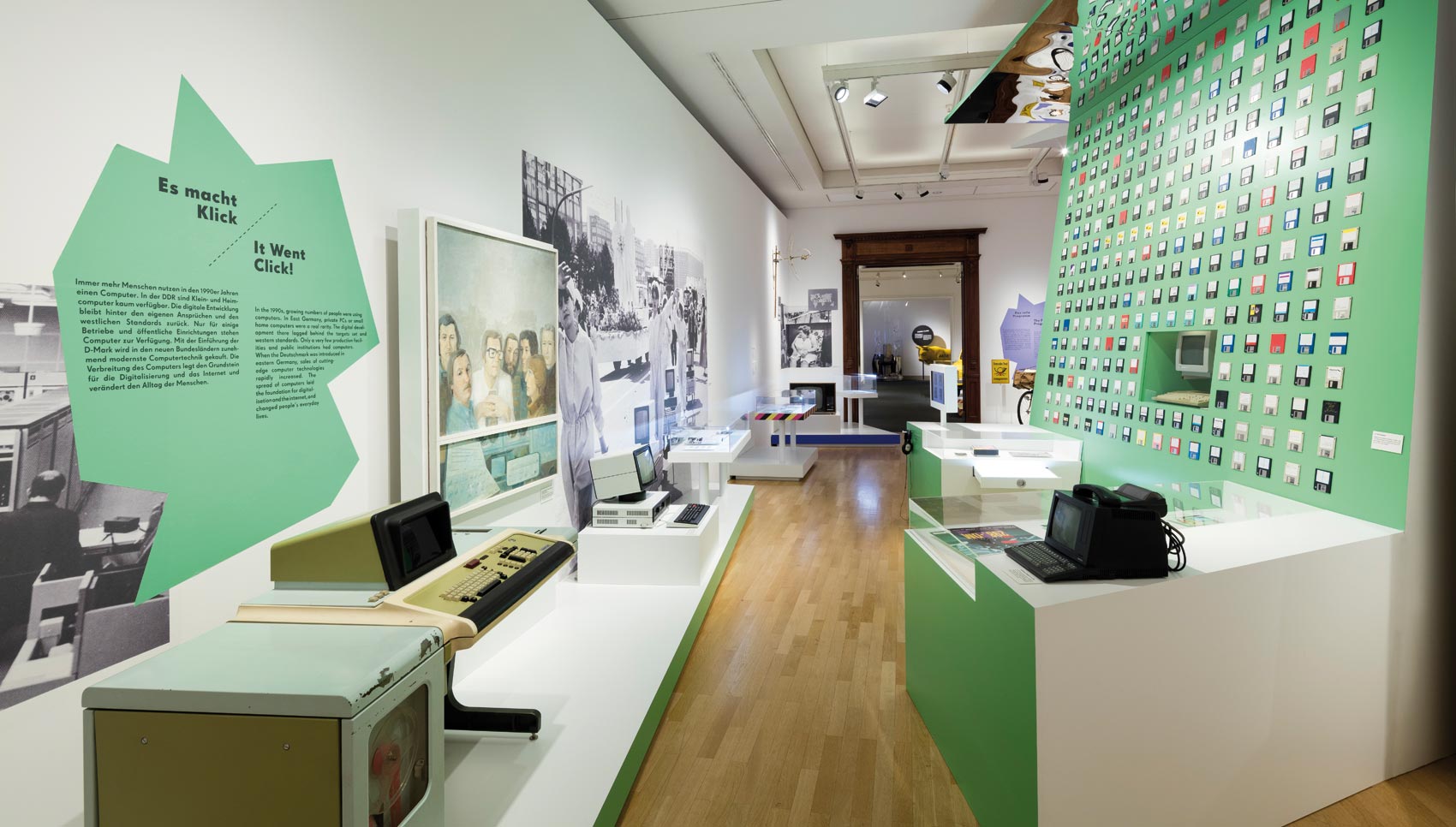 Raumblick grüne Ausstellungswand mit alten Computer-Exponaten