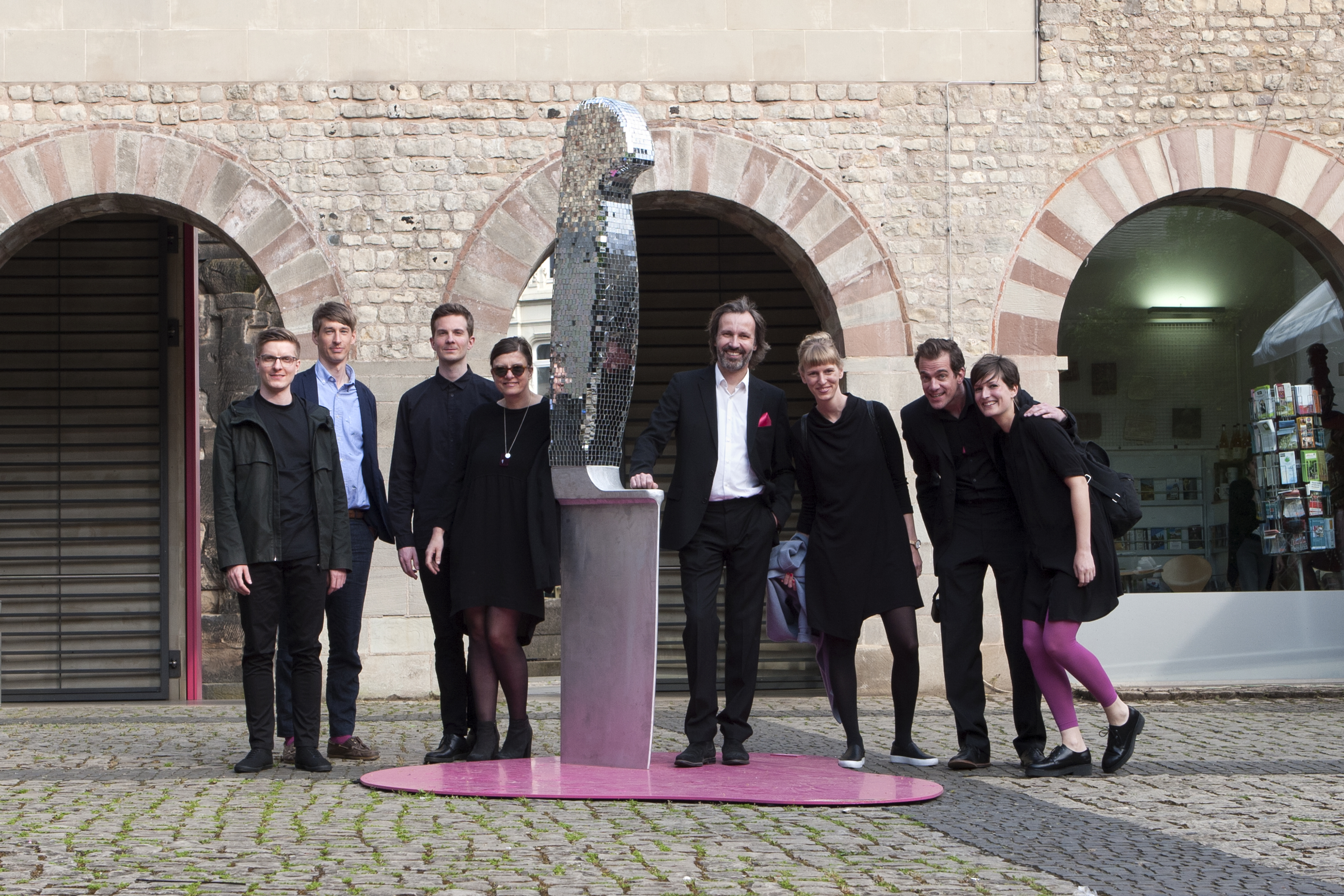 Das Team von res d vor einer Installation eines Messer, dass im Boden steckt