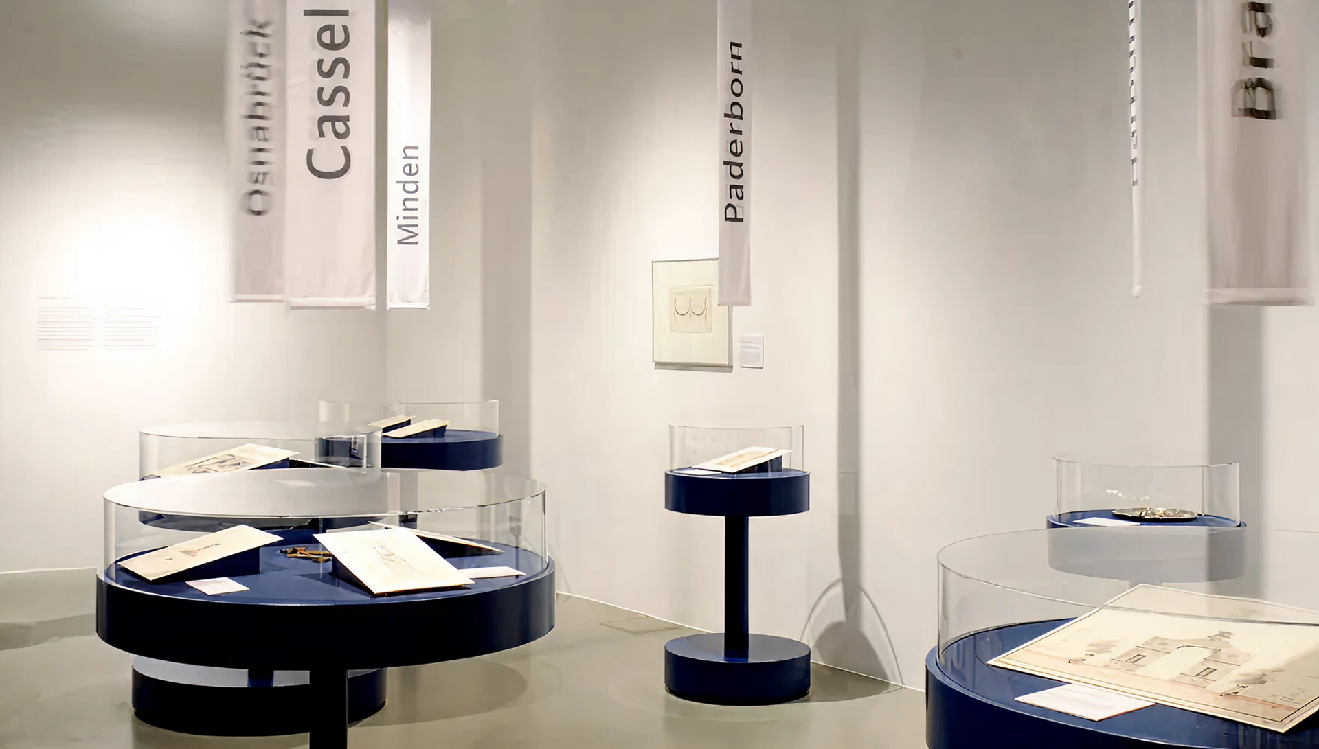 runde Aufsatzvitrinen mit verschiedenen Zeichnungen darin