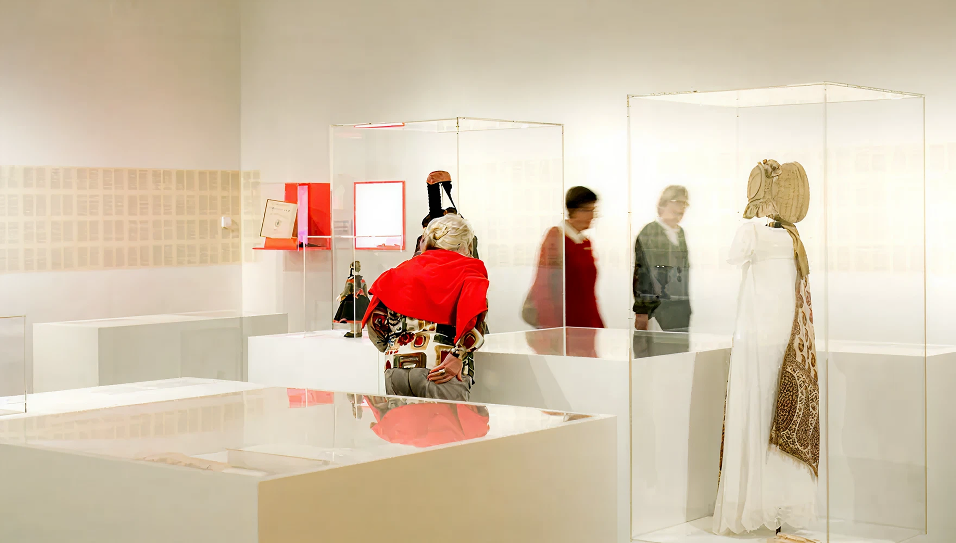 Weißer Raum und 2 menschengroße Vitrinen, in denen Kleidung zu sehen ist
