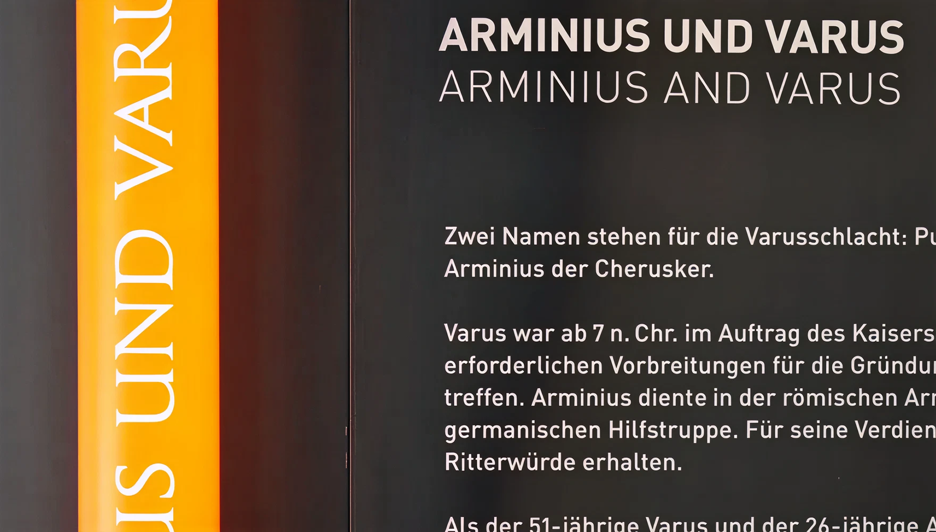 Weißer Text auf schwarzer Wand "Arminius und Varus"