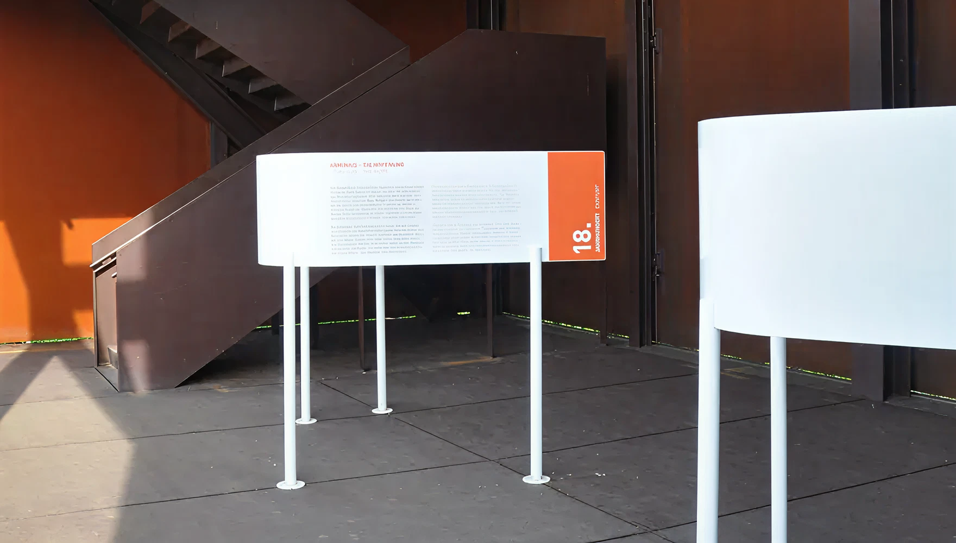 Gebogene weiße Ausstellungspaneele auf Füßen mit Schrift