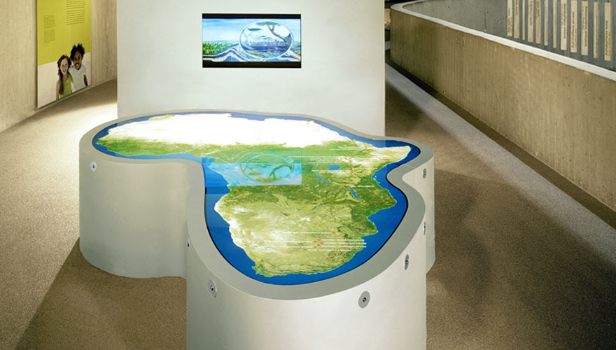 Weißer Tisch in der Form Afrikas mit leuchtender Karte von Afrika darauf