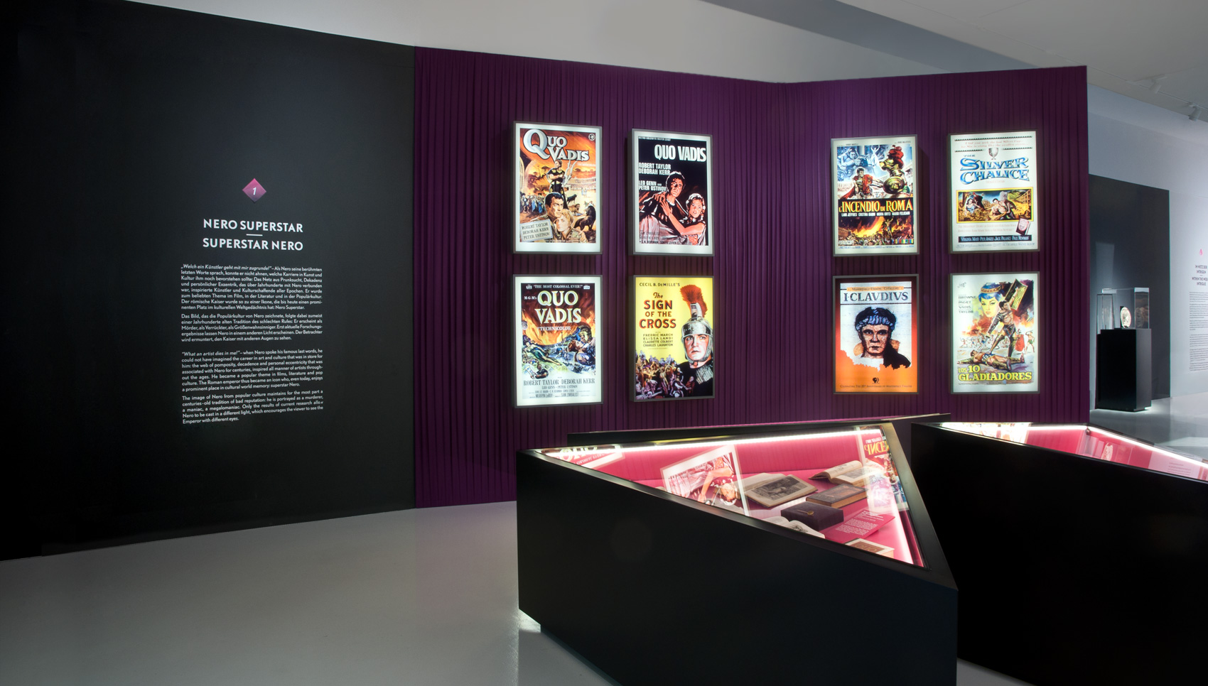 Blick auf dreieckige Einlassvitrinen und römische Filmposte im Hintergrund