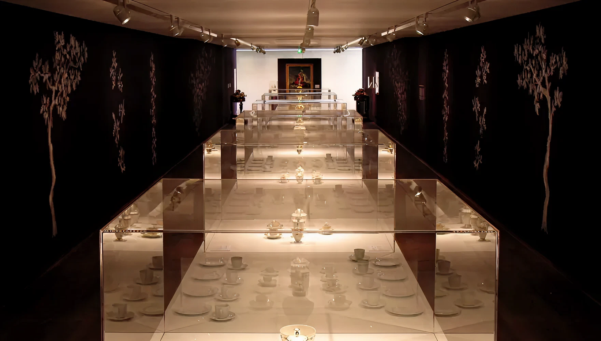 Blick über verschiedene Aufsatzvitrinen. Dunkle Beleuchtung.