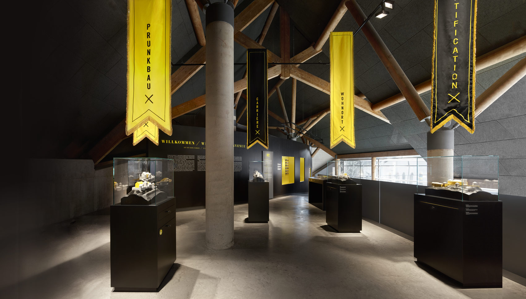 Ausstellungsraum mit schwarzen Ausstellungsmöbeln mit gelb-leuchtenden Akzenten