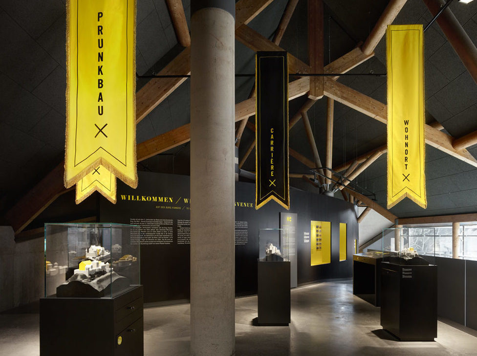 Ausstellungsraum mit schwarzen Ausstellungsmöbeln mit gelb-leuchtenden Akzenten