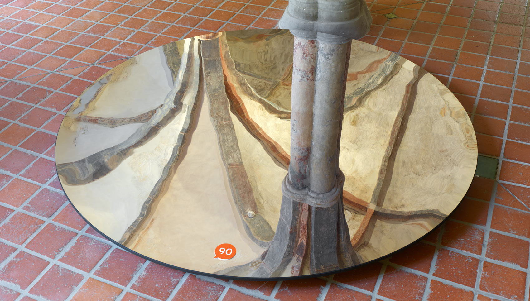 Runder Spiegel, der auf dem Boden liegt und die historische Decke spiegelt