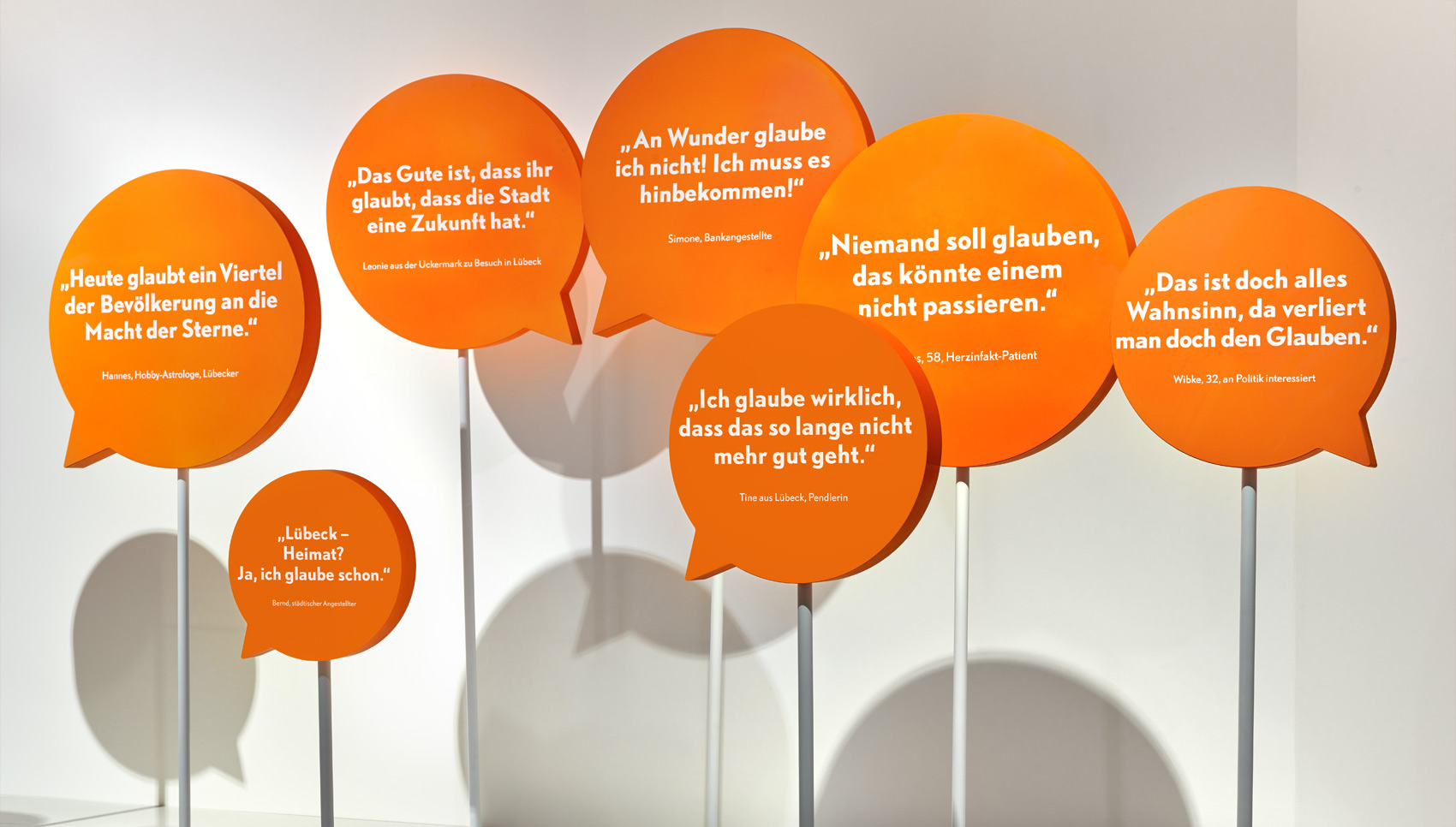 Ausstellungsgrafik mit gebauten orangenen Sprechblasen