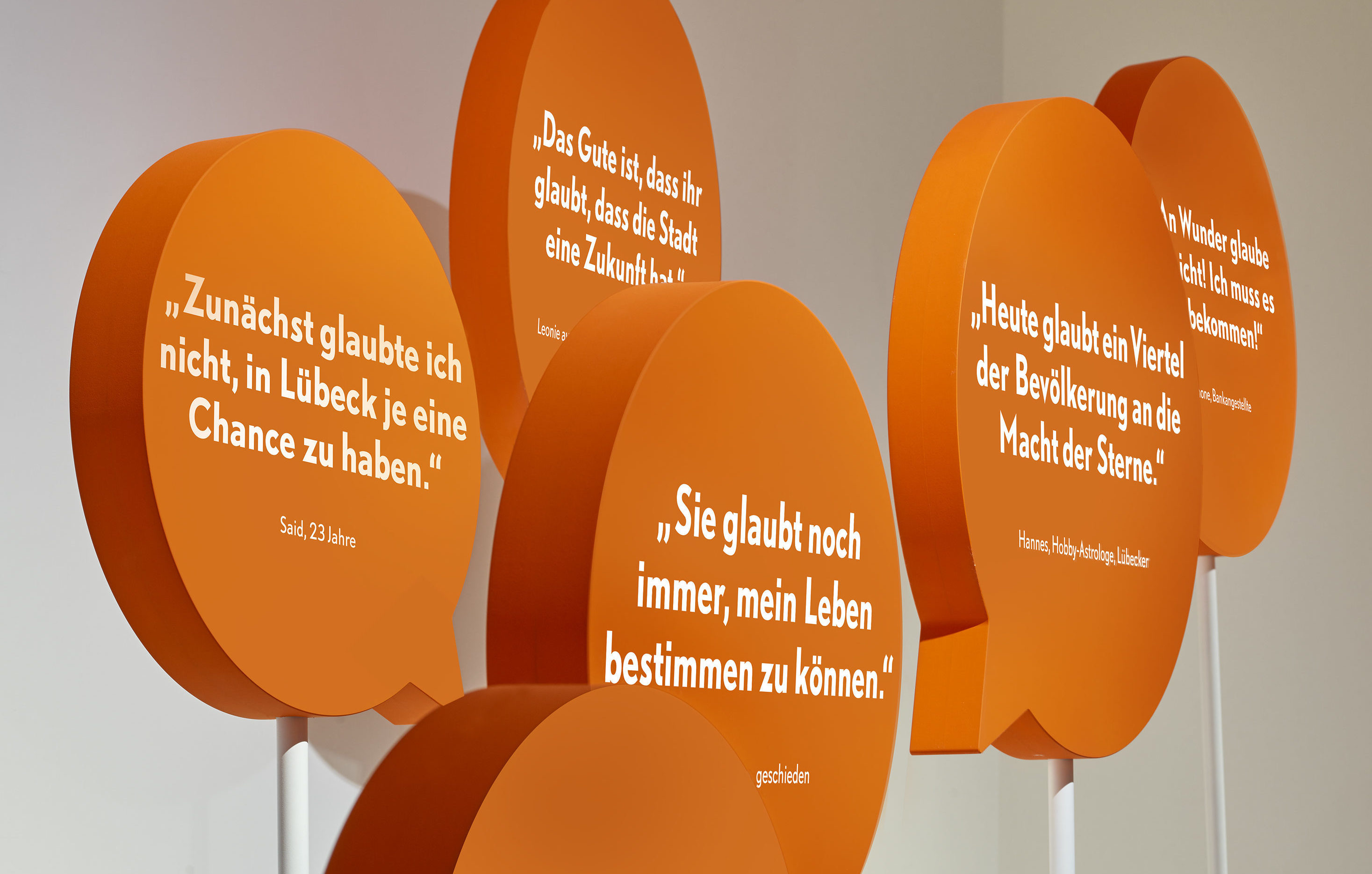 Ausstellungsgrafik mit gebauten orangenen Sprechblasen
