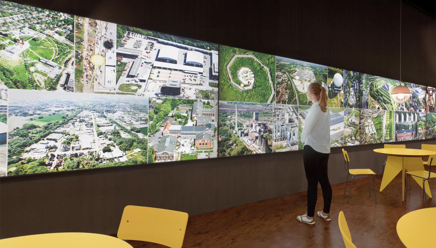 Frau steht vor einer hinterleuchteten Ausstellungswand