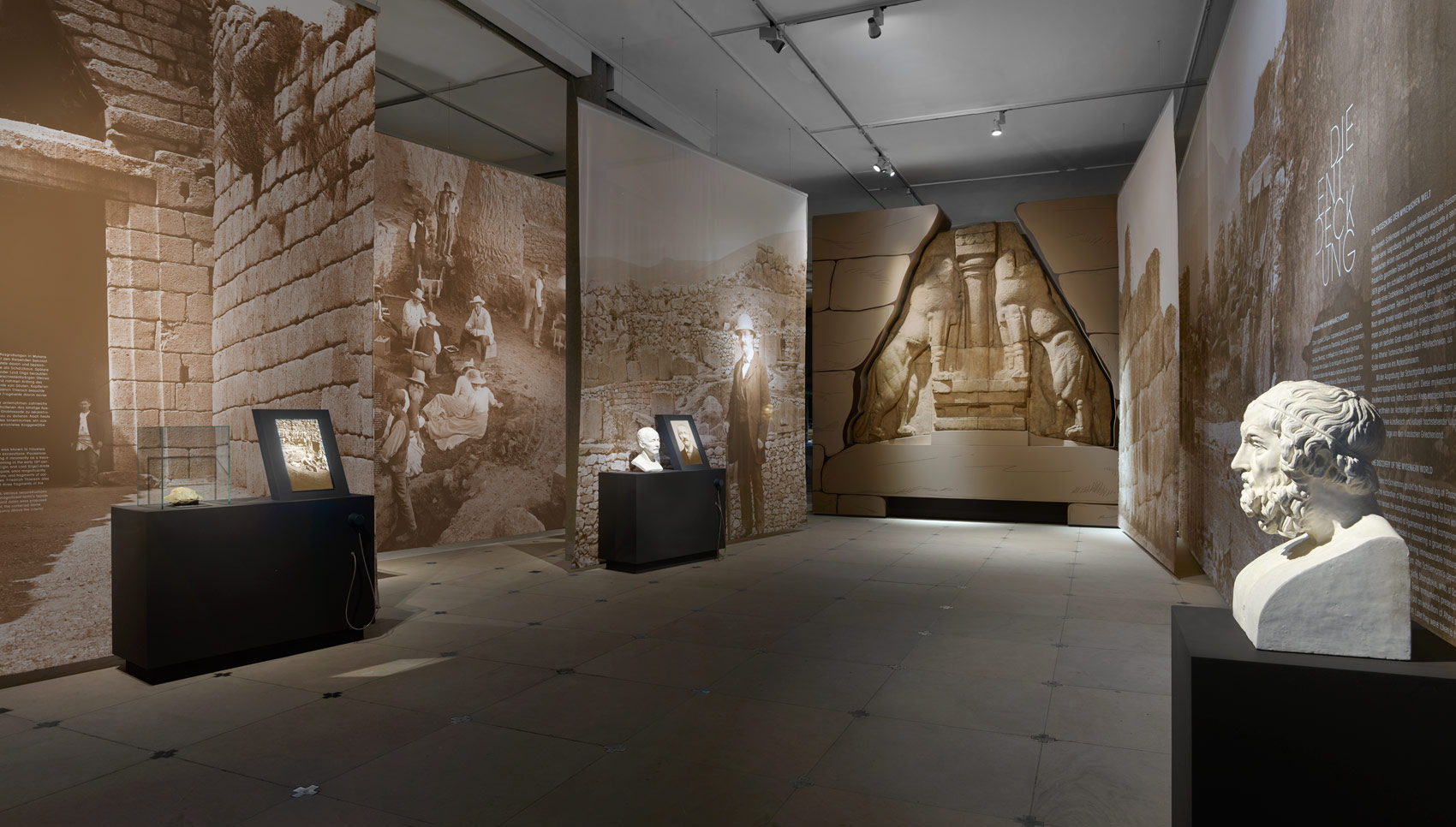 Ausstellungsraum mit verschiedenen Exponaten und bedruckten Stoffen, die den Raum trennen