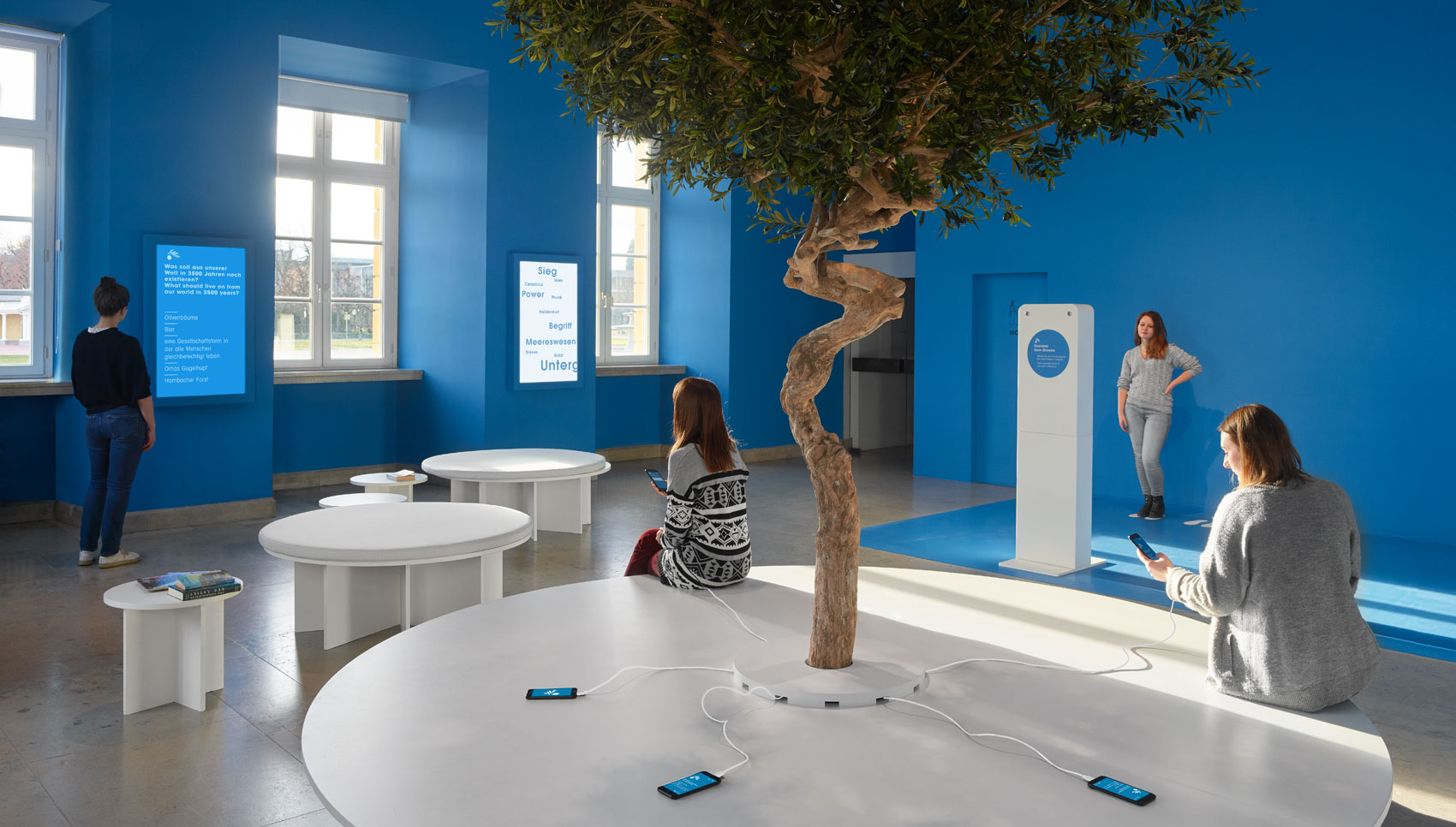 Blauer Ausstellungsraum mit Sitzgelegenheiten