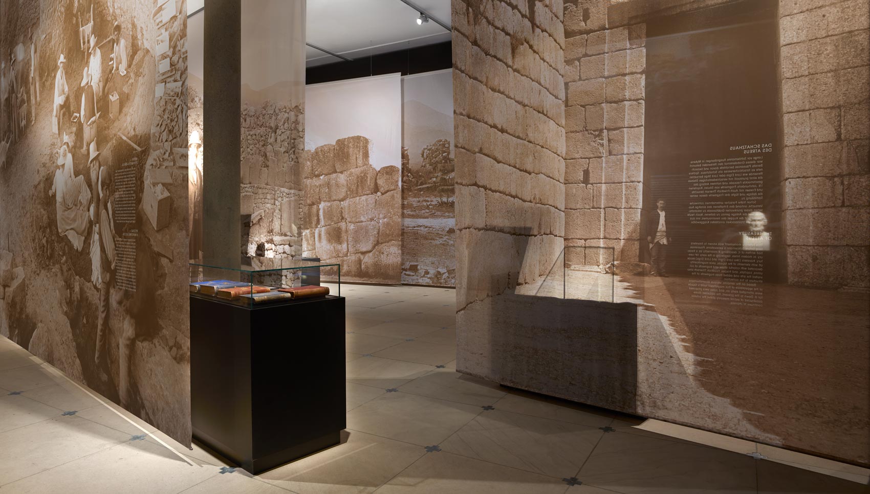 Ausstellungsraum mit verschiedenen Exponaten und bedruckten Stoffen, die den Raum trennen