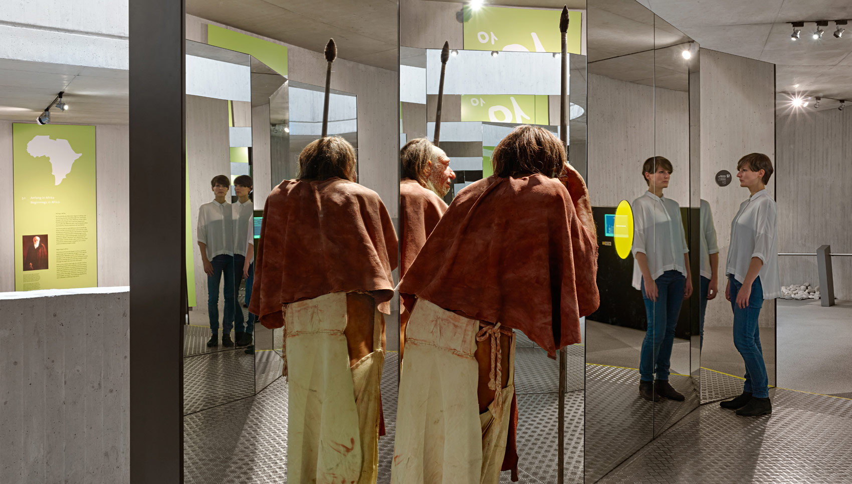 Frau steht mit einer menschengroßen Ausstellungs-Figur in einem Spiegelkabinett