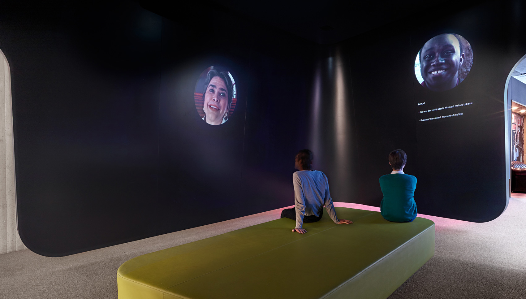 Zwei sitzende Menschen schauen sich Projektionen an