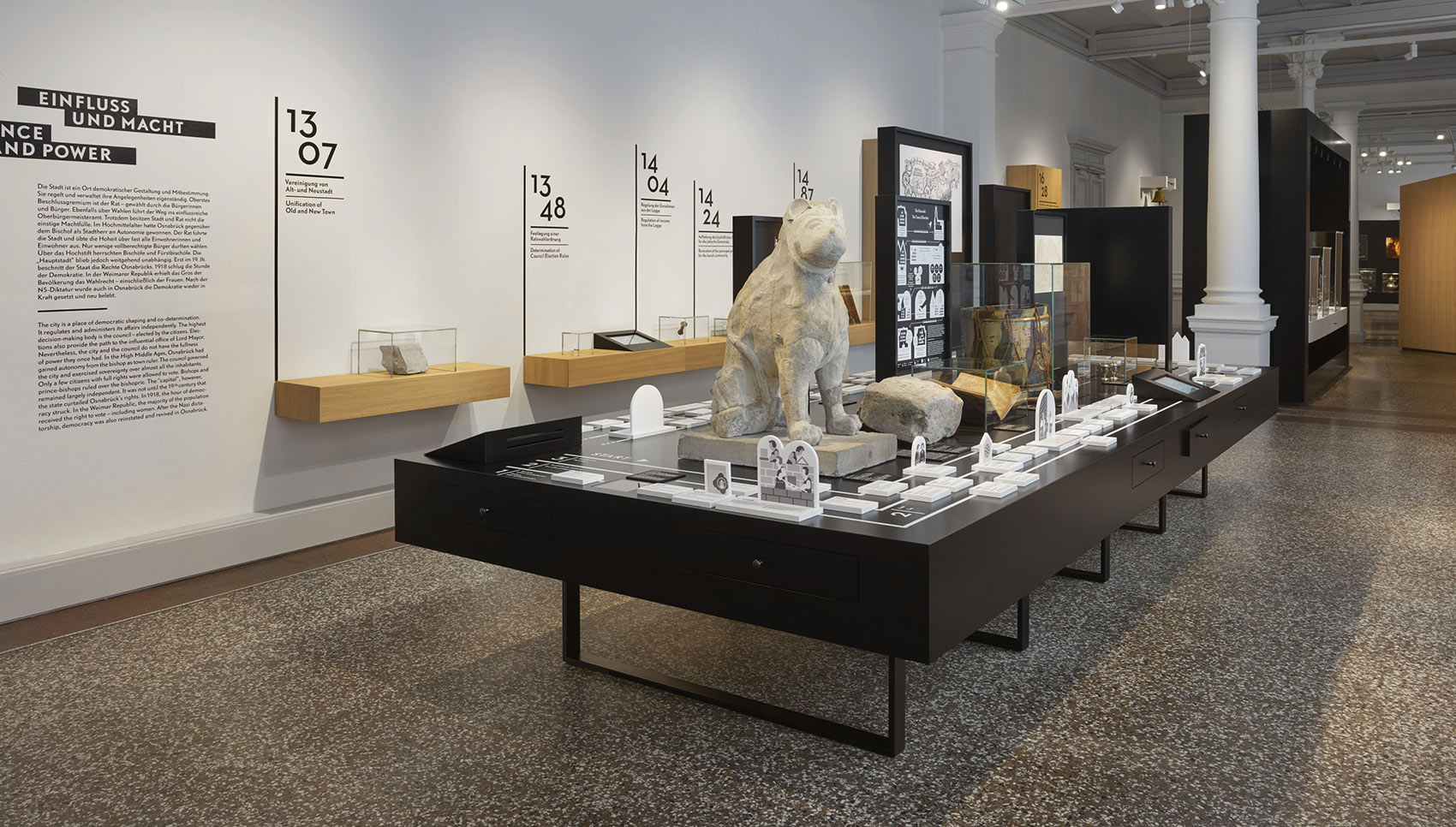 Ausstellungsraum mit schwarzem Ausstellungsmöbel und verschiedenen Exponaten