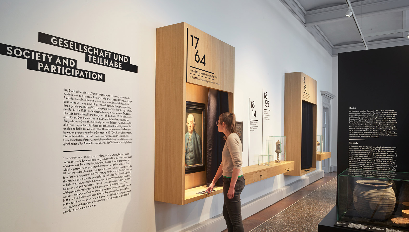 Person steht vor einem interaktiven Ausstelllungsmöbel