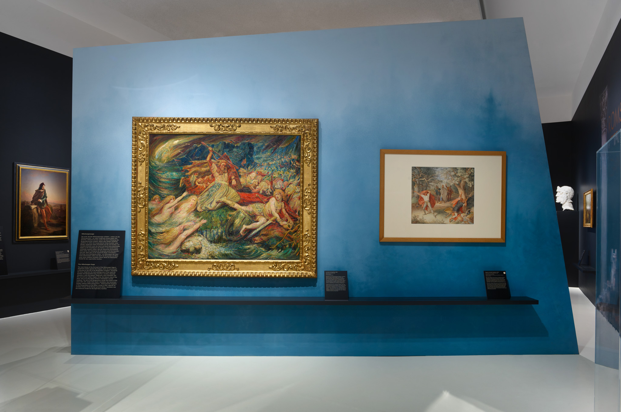 Ausstellungsraum mit Gemälden und Wandgrafiken