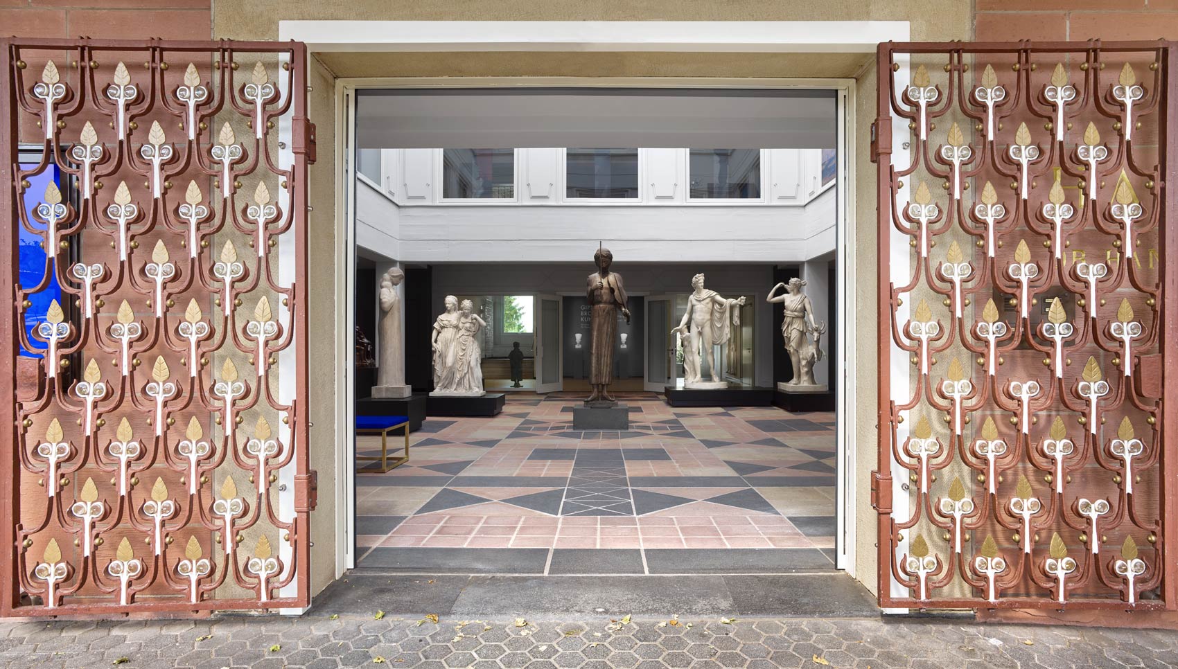 Blick durch Tor in den Ausstellungsraum mit Skulpturen