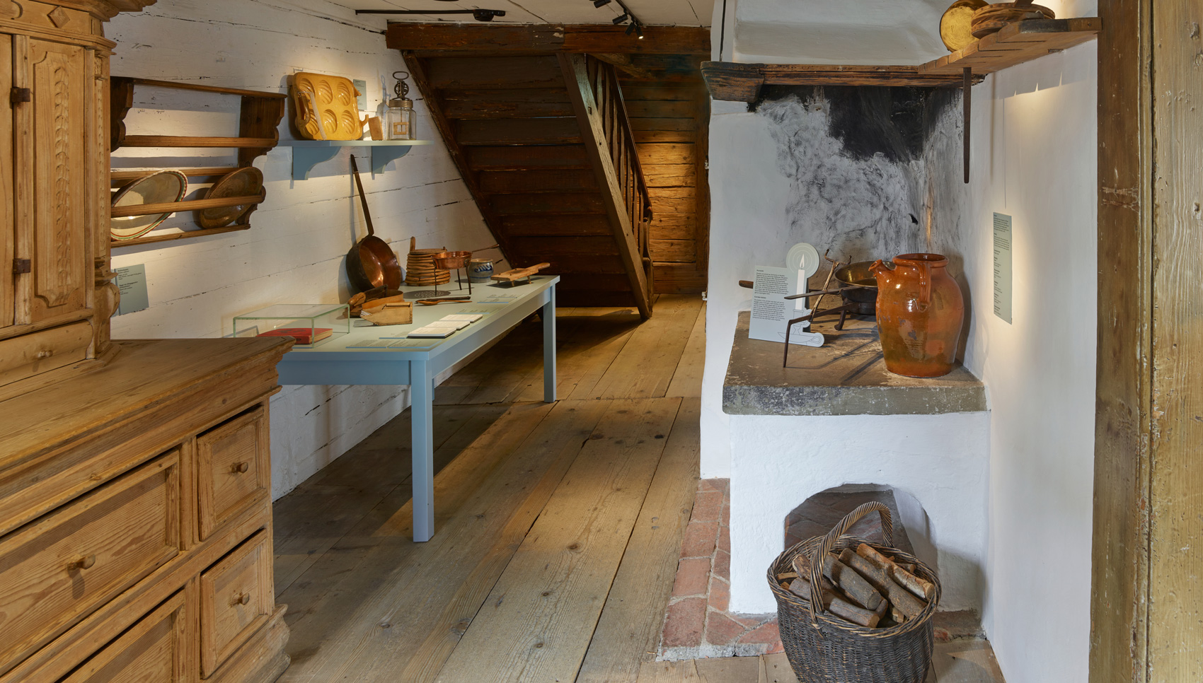 Ausstellungsraum mit Ausstellungsmöbeln und verschiedenen Expnaten – einem Wohnraum eines historischen Bauernhauses nachempfunden.