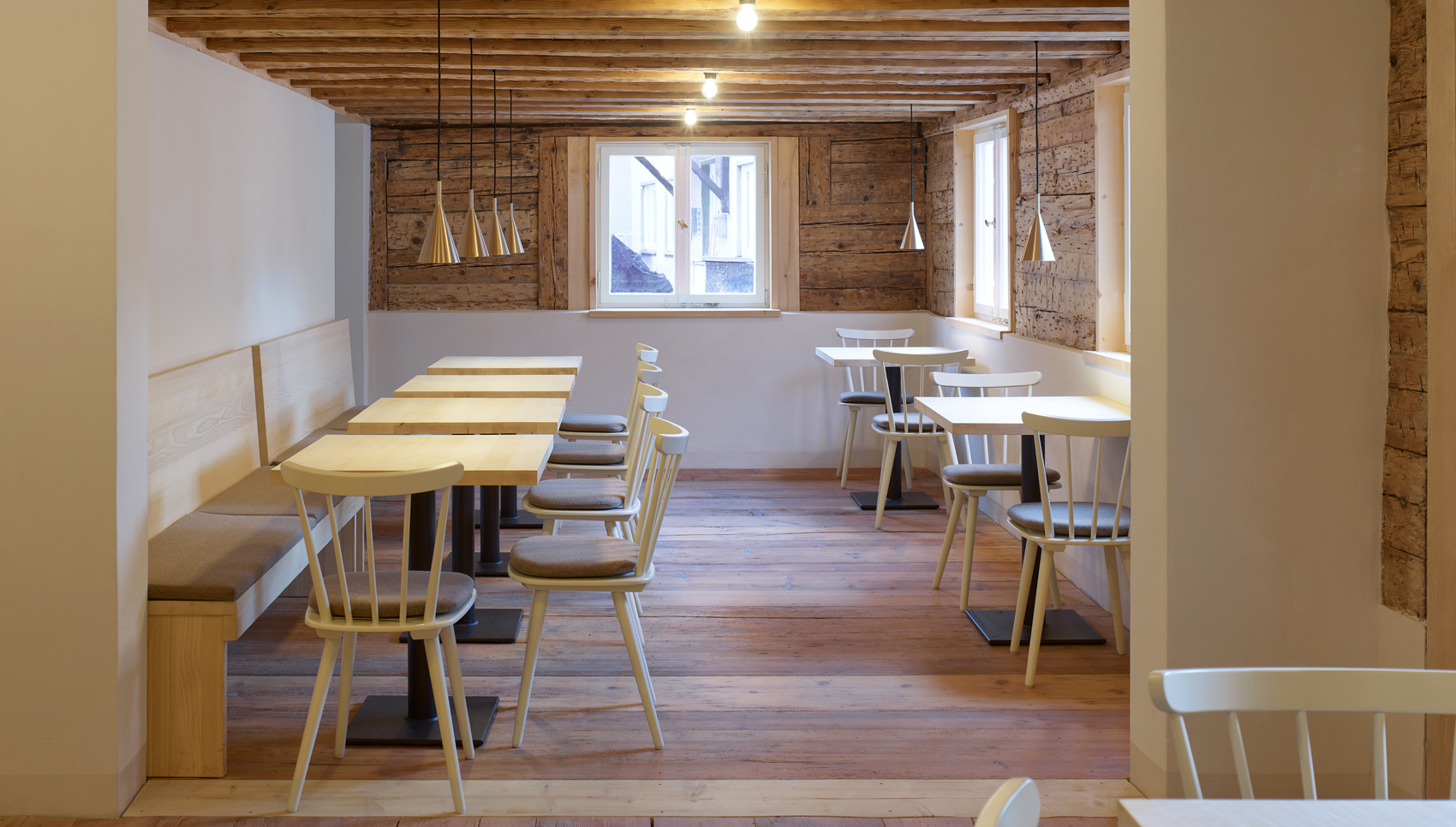 Raum mit Tischen, Bänken und Stühlen