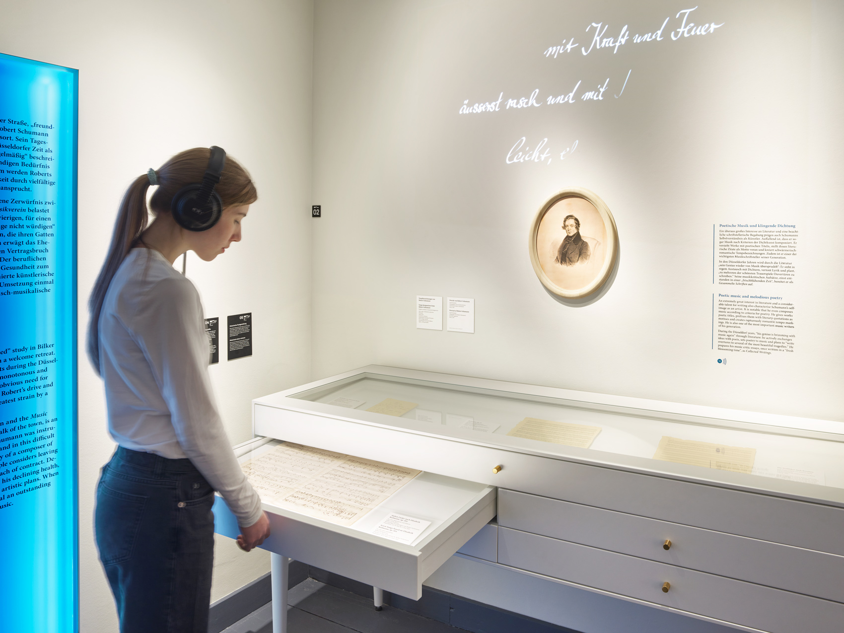 Person im Ausstellungsraum mit interaktivem Ausstellungsmöbeln und verschiedenen Exponaten