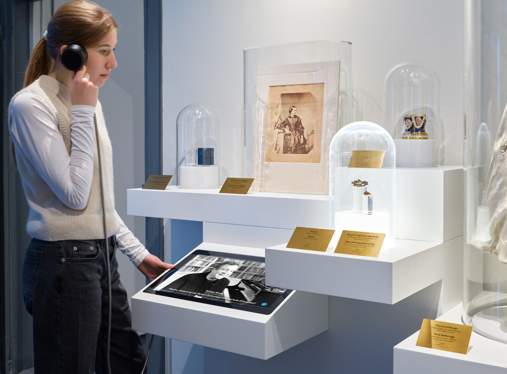 Person im Ausstellungsraum mit interaktivem Ausstellungsmöbeln und verschiedenen Exponaten