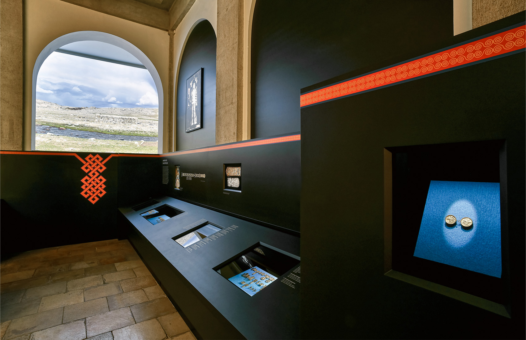 Ausstellungsraum mit schwarzen Ausstellungsmöbeln und verschiedenen Exponaten