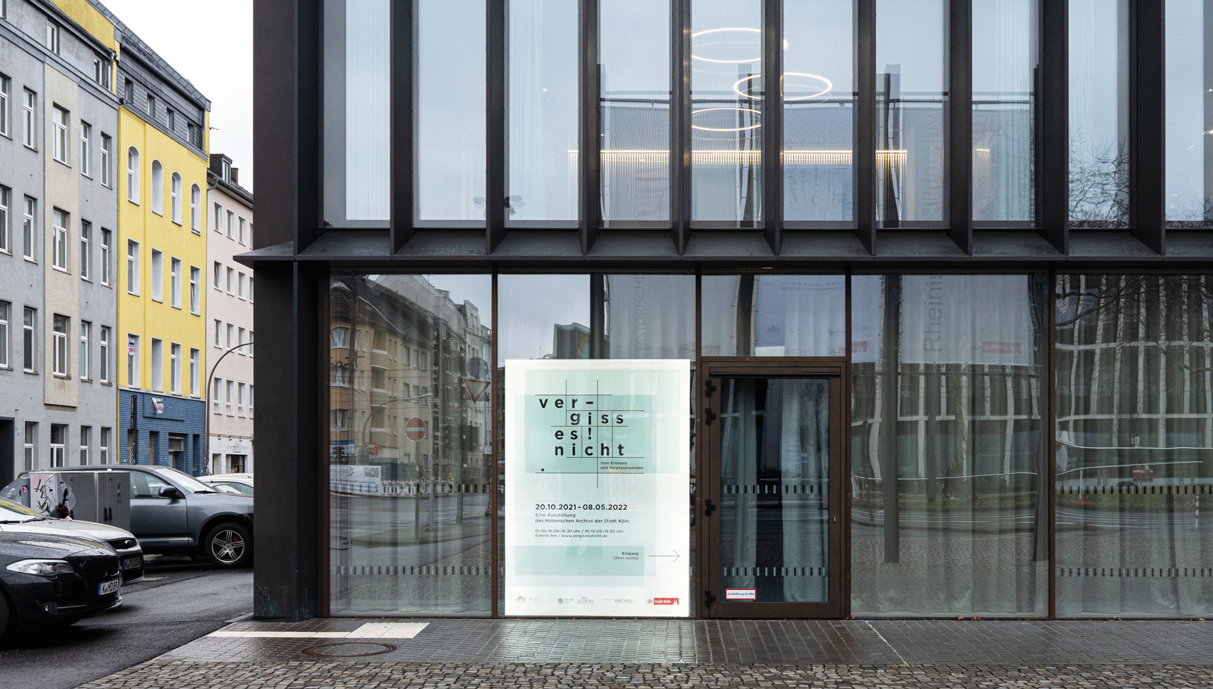 Außenbereich mit menschhohen Ausstellungsposter