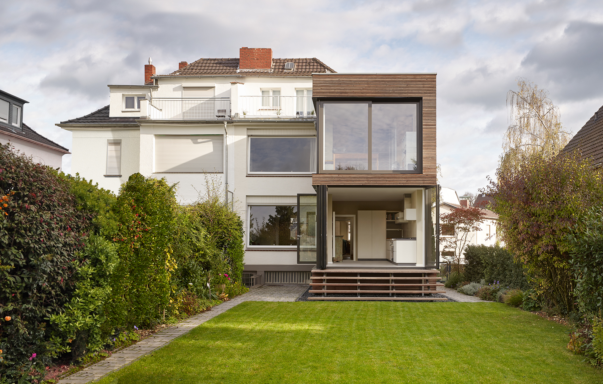 Blick auf den Anbau vom Garten aus mit offenen Türen