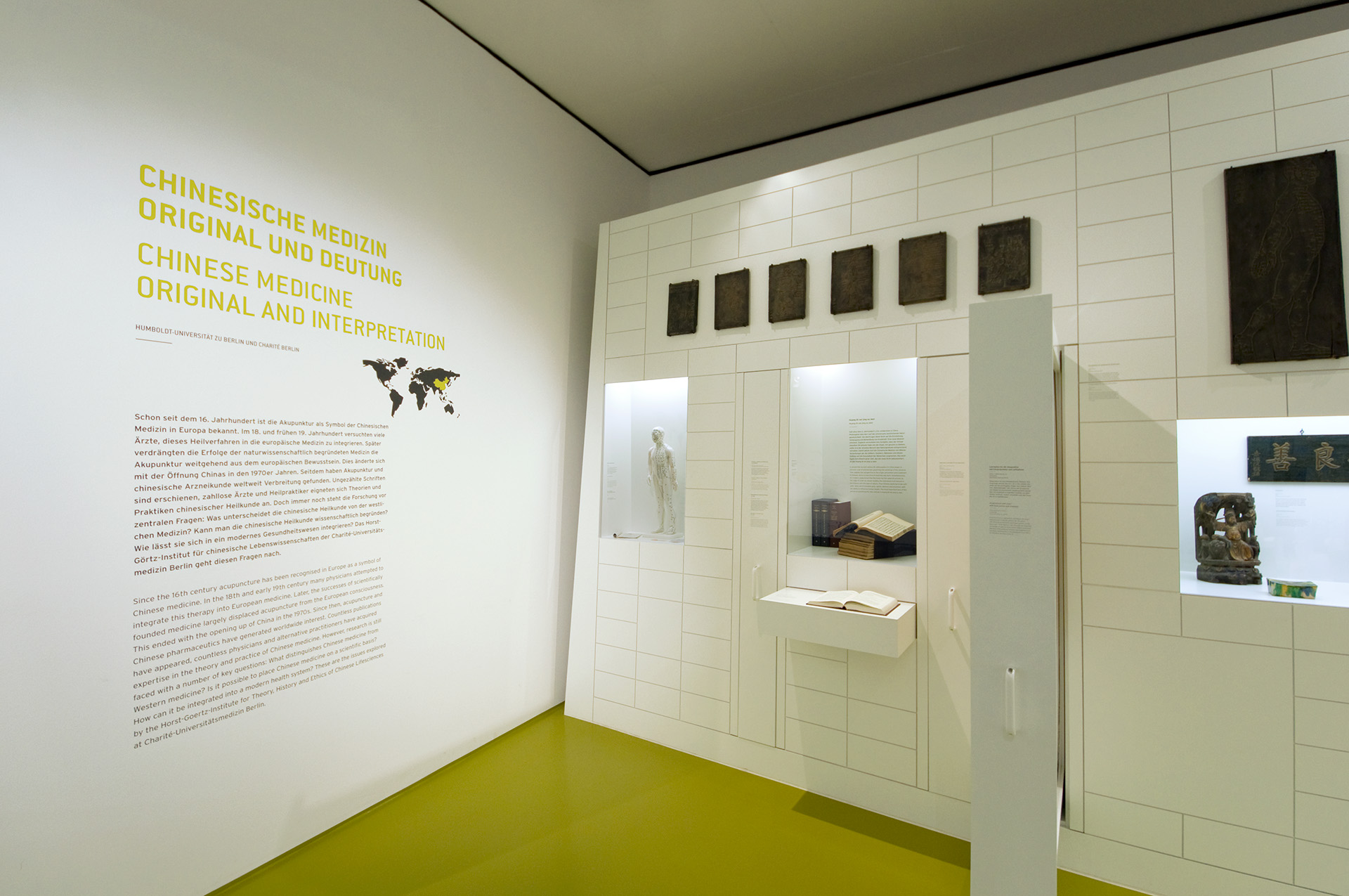 Ausstellungswand mit Einlassvitrinen und Text "Chinesische Medizin"