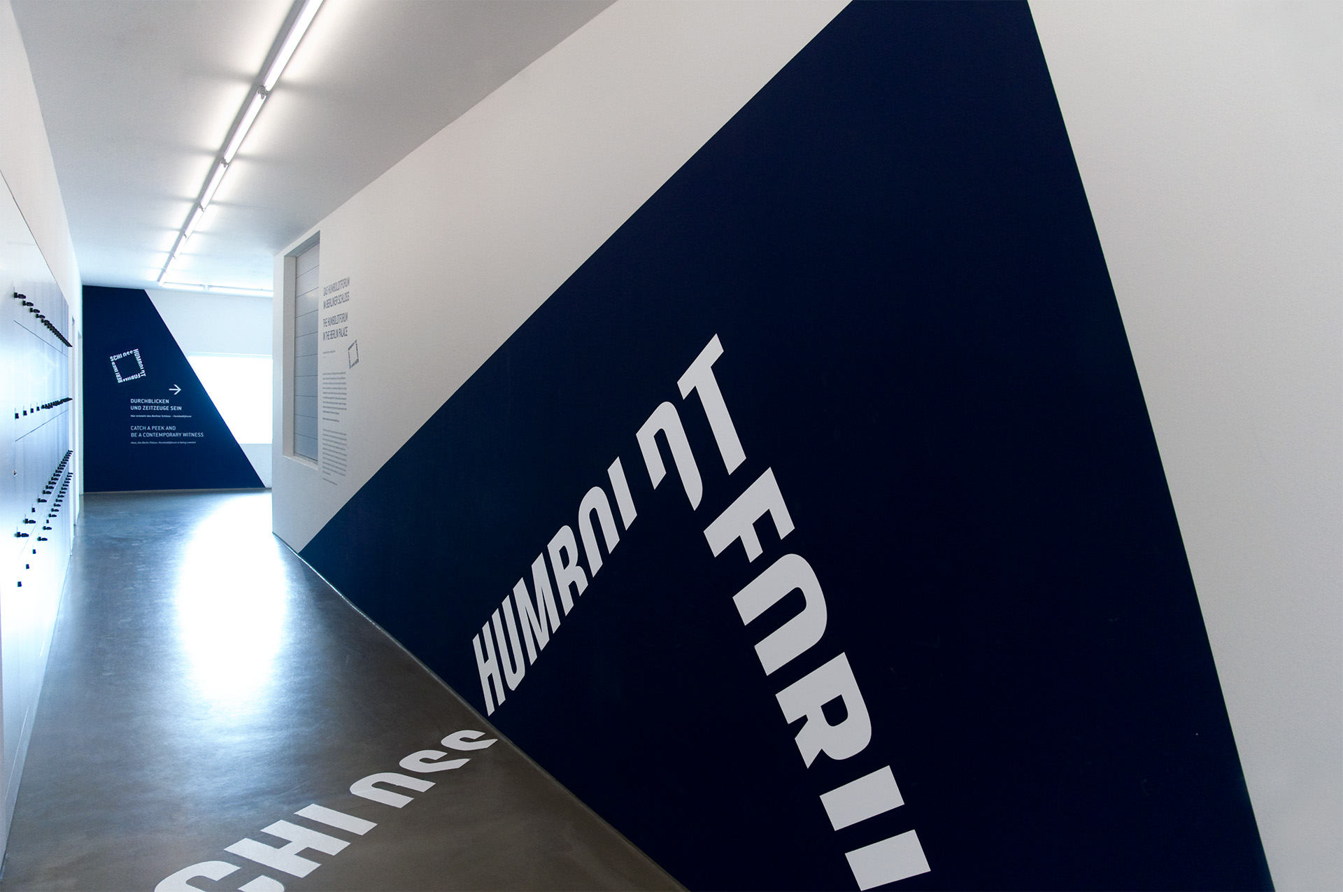 Ausstellungswand mit dunkelblauem Dreieck auf dem "Humboldt Forum" steht