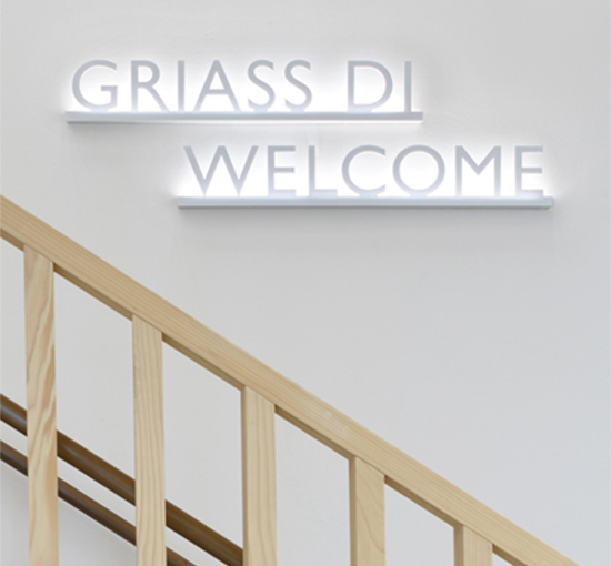 Foto mit Leuchtschrift „GRIASS DI WELCOME“