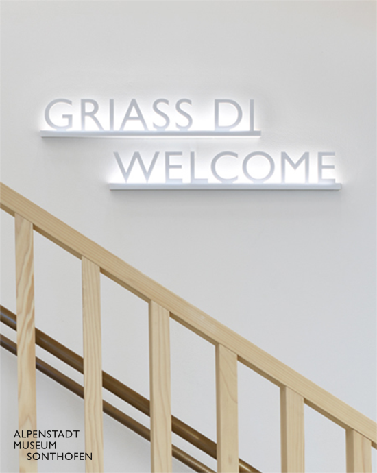 Foto mit Leuchtschrift „GRIASS DI WELCOME“