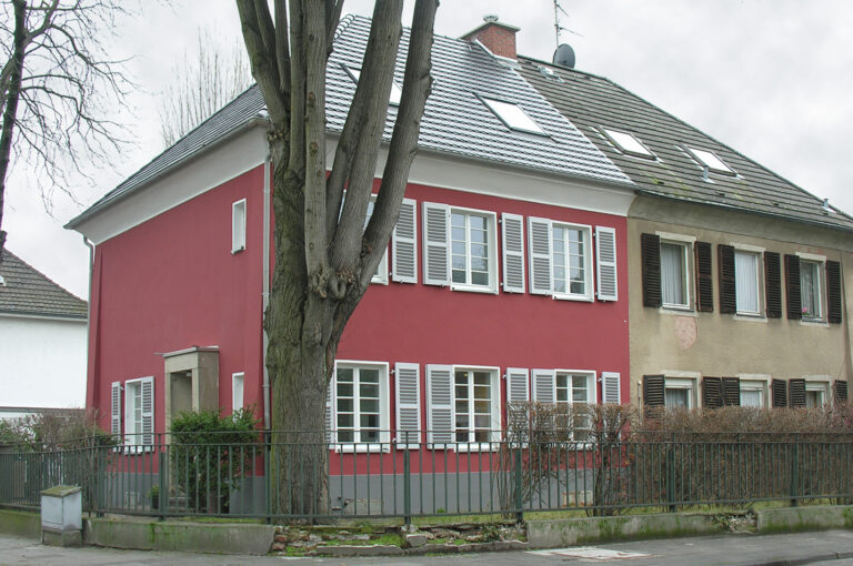 Blick auf Haus mit roter Wandfarbe von Straße aus