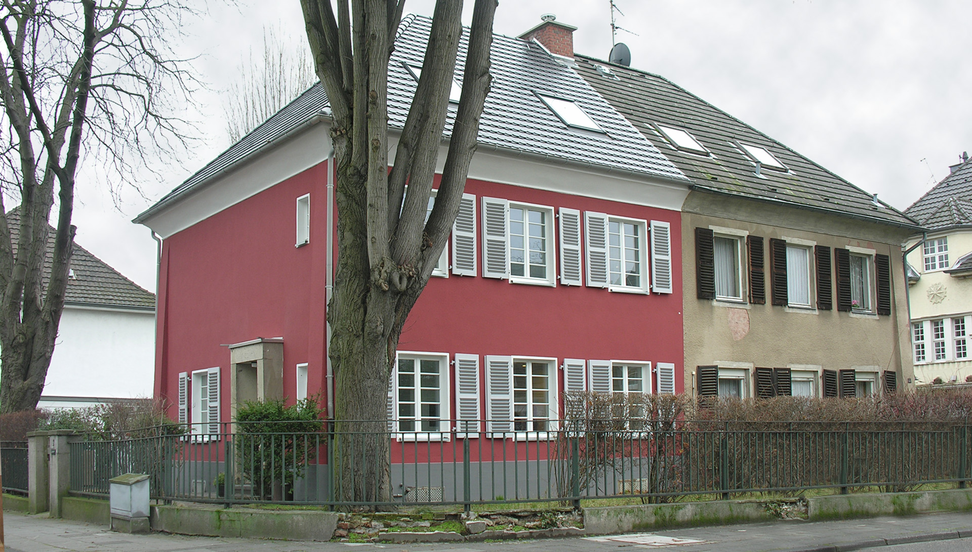 Blick auf Haus mit roter Wandfarbe von Straße aus