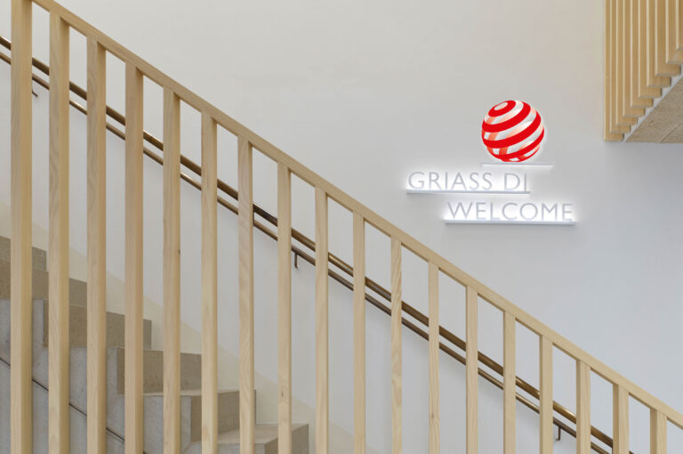 Treppenaufgang mit Fokus auf Wandschild "Griass Di – Welcome"
