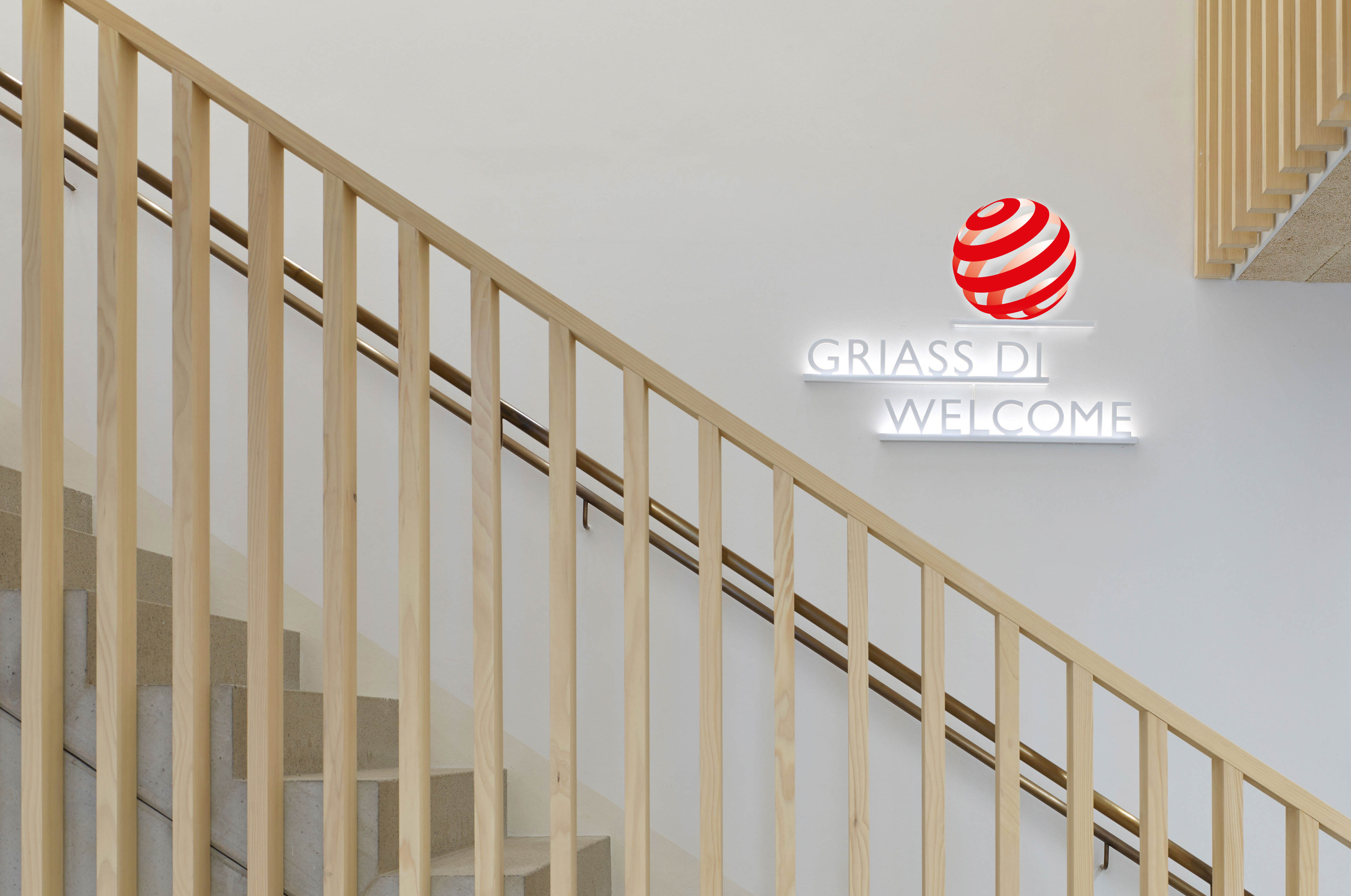 Treppenaufgang mit Fokus auf Wandschild "Griass Di – Welcome"