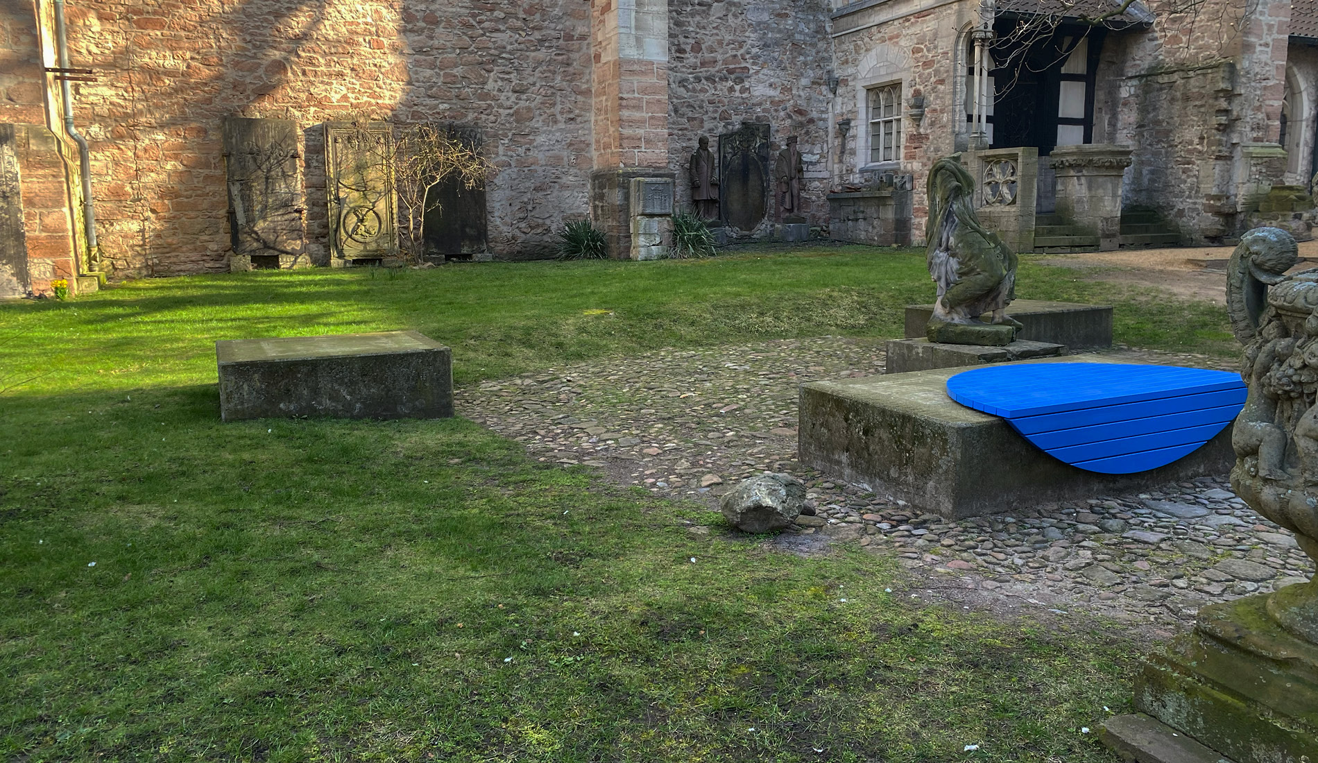 Foto der Kirche hinter Ägidien mit einer blauen runden Sitzfläche