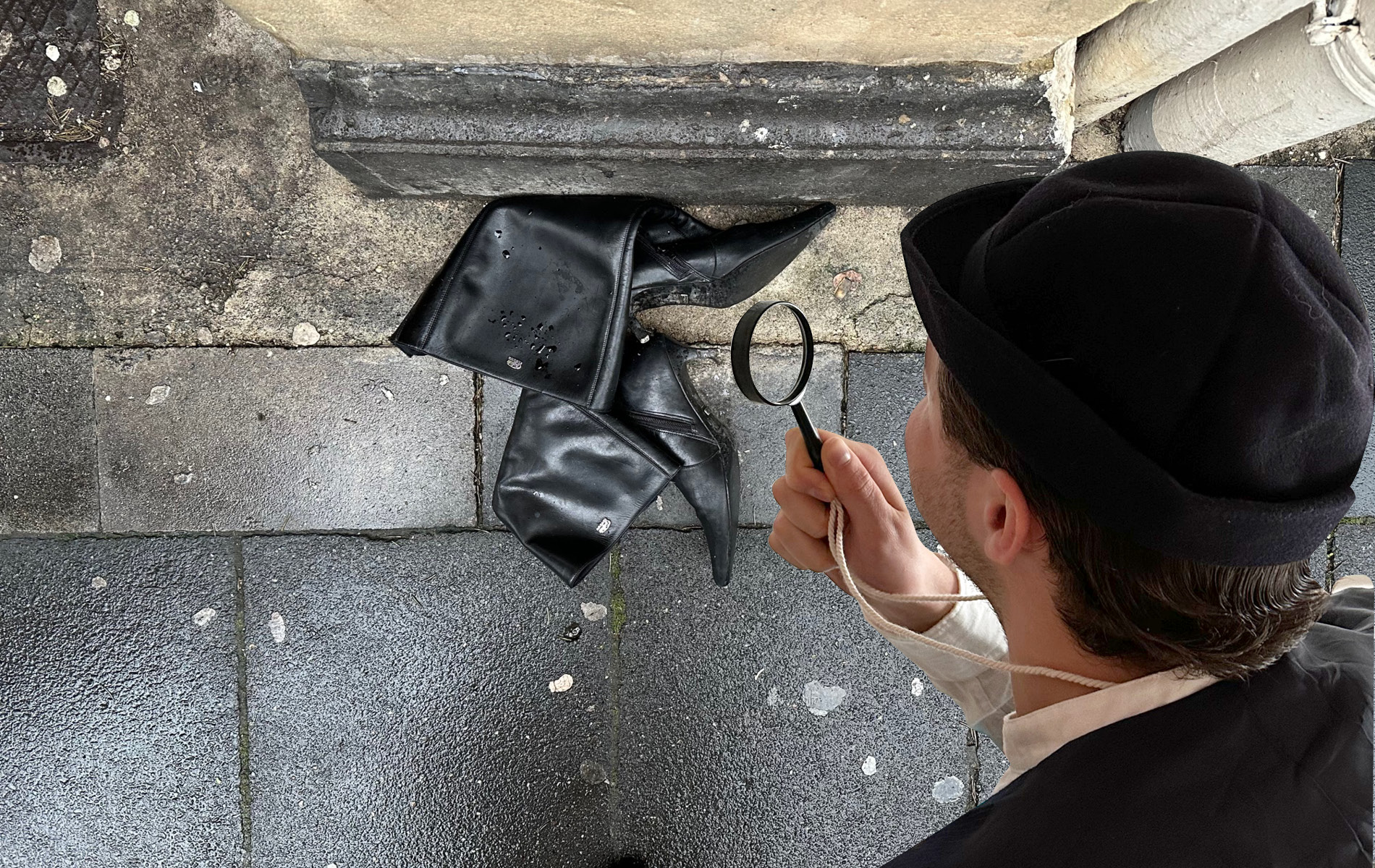 res d Mitarbeiter verkleidet als Detektiv untersucht mit seiner Lupe schwarze Overknees auf der Straße