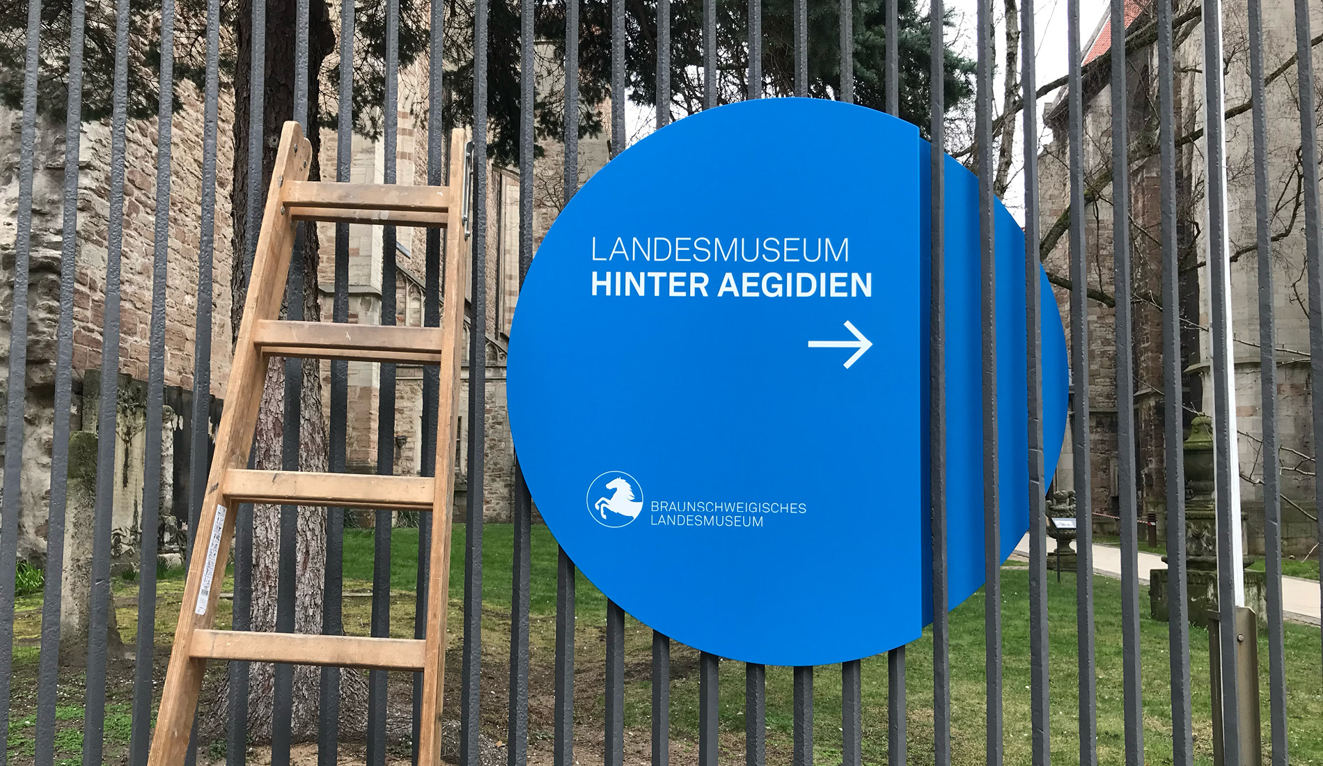 rundes Orientierungsschildes in Blau montiert in Zaungittern